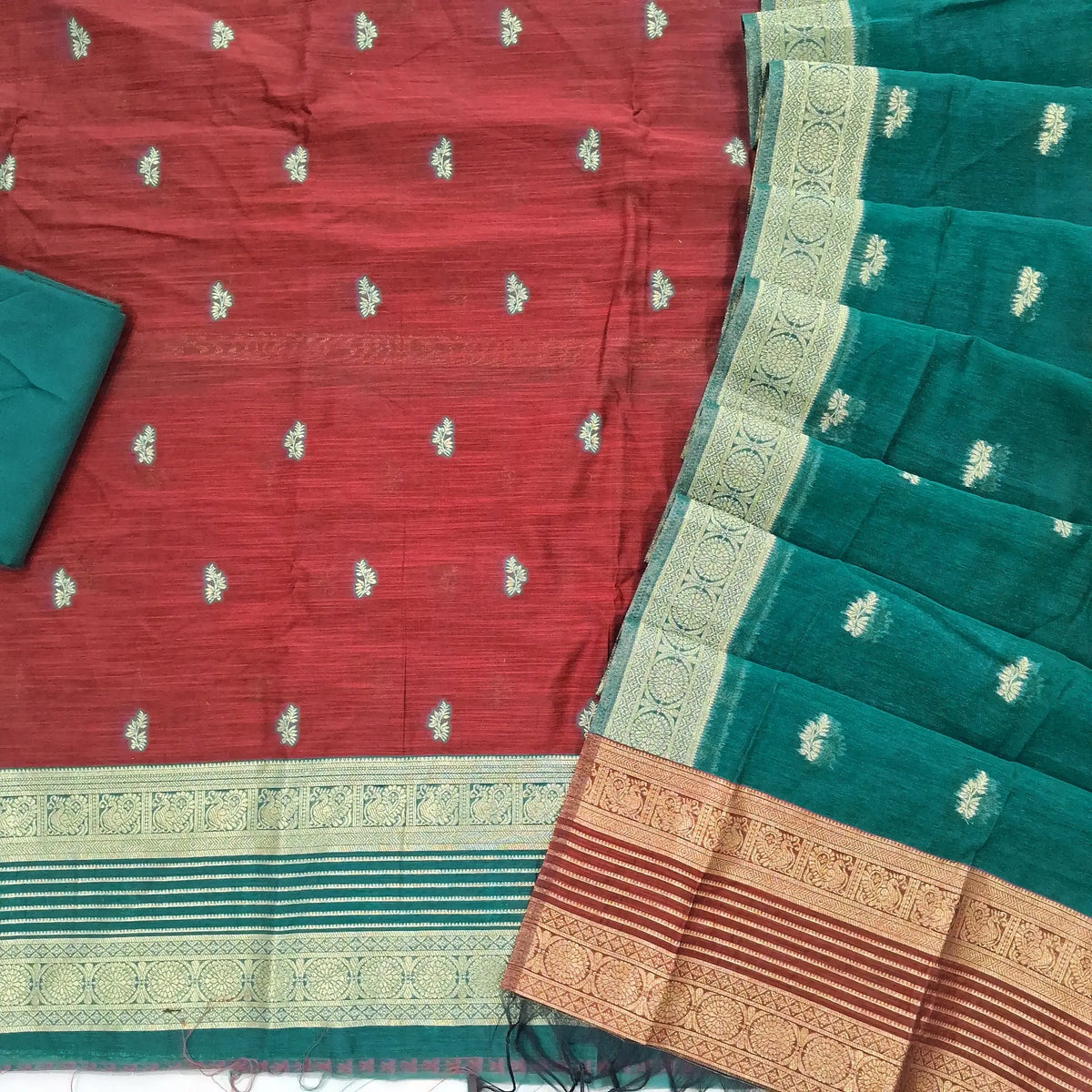 Maroon premium silk cotton unstitched salwar material,buttas all over benarasi zari weaving daman, (lining needed)teal green silky bottom,buttas on silk cotton dupatta with contrast pallu and borders. SP262207