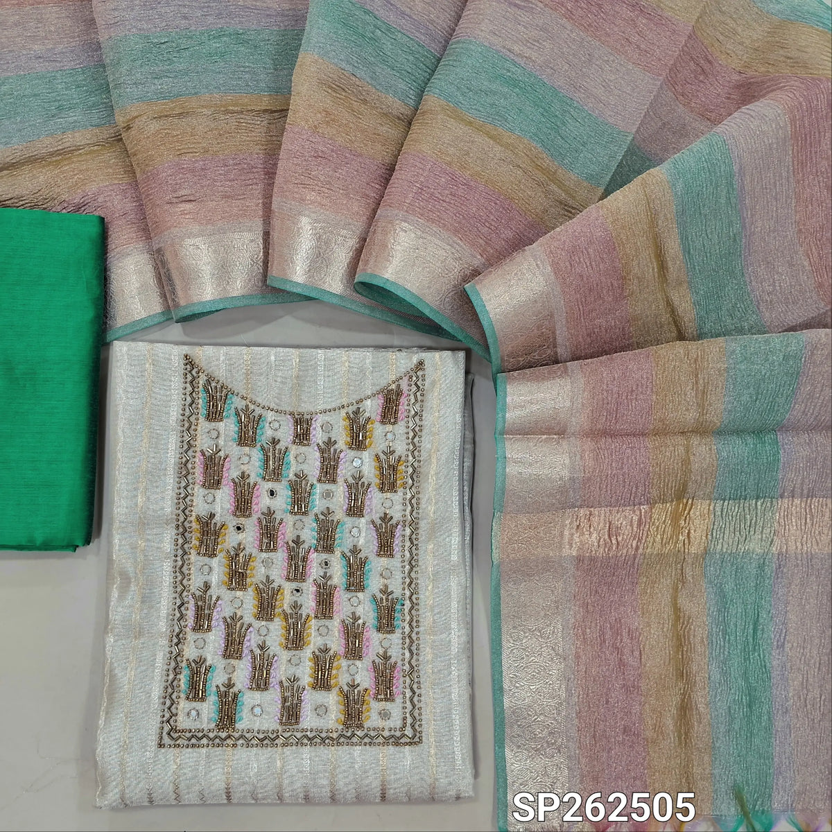Light beige tissue silk cotton unstitched salwar material,cut bead, sugar bead and thread work on yoke,gold & silver zari weaving(lining needed)turquoise green silk cotton bottom,multicoloured crinkled tissue silk cotton dupatta. SP262505