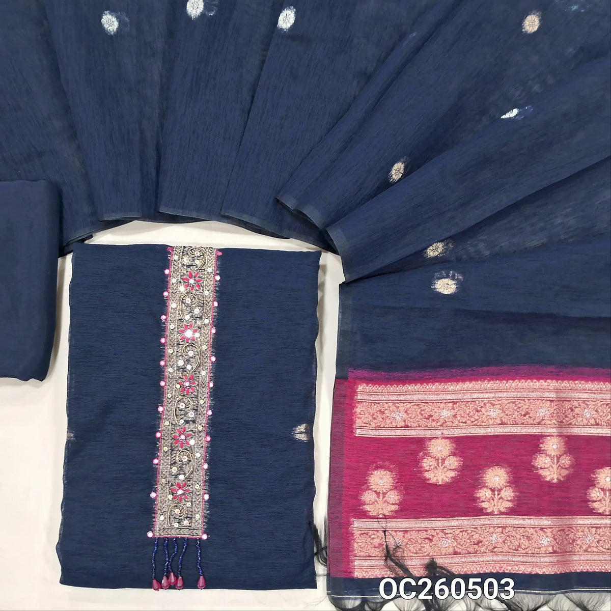Dark blue premium tussar unstitched salwar material,thread, zarodzi and  faux mirror work on yoke,gold and silver zari buttas all over, rich weaving daman,(lining needed)santoon bottom, buttas on tussar dupatta with rich contrast pallu. OC260503