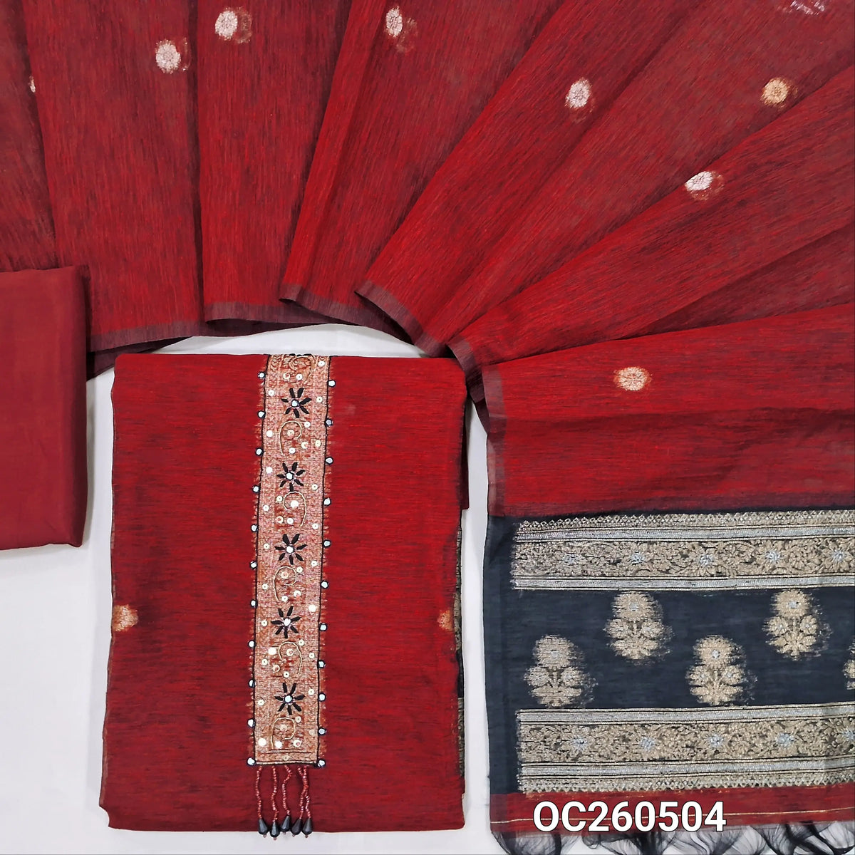 Maroon premium tussar unstitched salwar material,thread, zarodzi and  faux mirror work on yoke,gold and silver zari buttas all over, rich weaving daman,(lining needed)santoon bottom, buttas on tussar dupatta with rich contrast pallu. OC260504