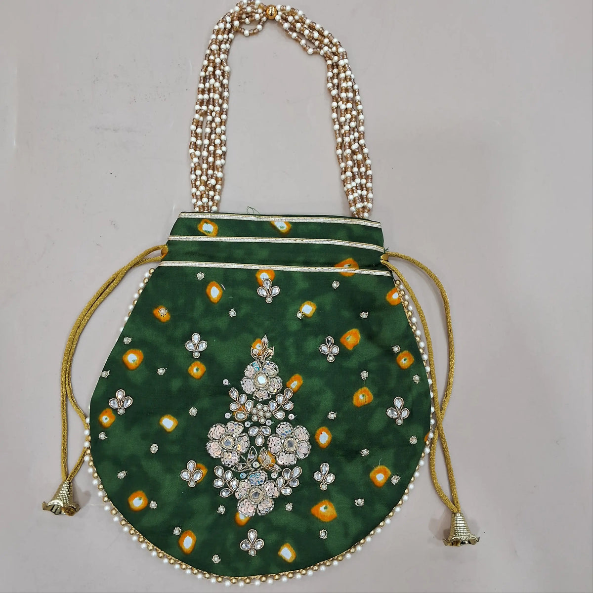 leafy green pure gaiji silk unstitched salwar material, zarodzi, pearl bead and sequins work on yoke,tie and dye all over,(lining optional)tie and dye gaiji silk bottom, pure organza dupatta with gota and pearl bead tapping and potli bag. OC260602
