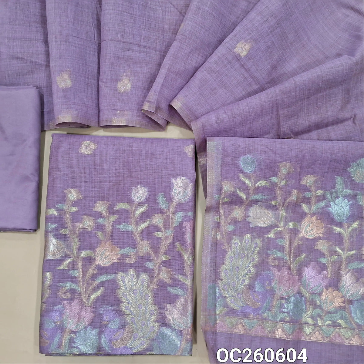 Lavender premium silk cotton unstitched salwar material,buttas on front,rich pastel weaving on daman,(lining needed)silky bottom, buttas on full length silk cotton dupatta with rich pastel zari weaving pallu. OC260604