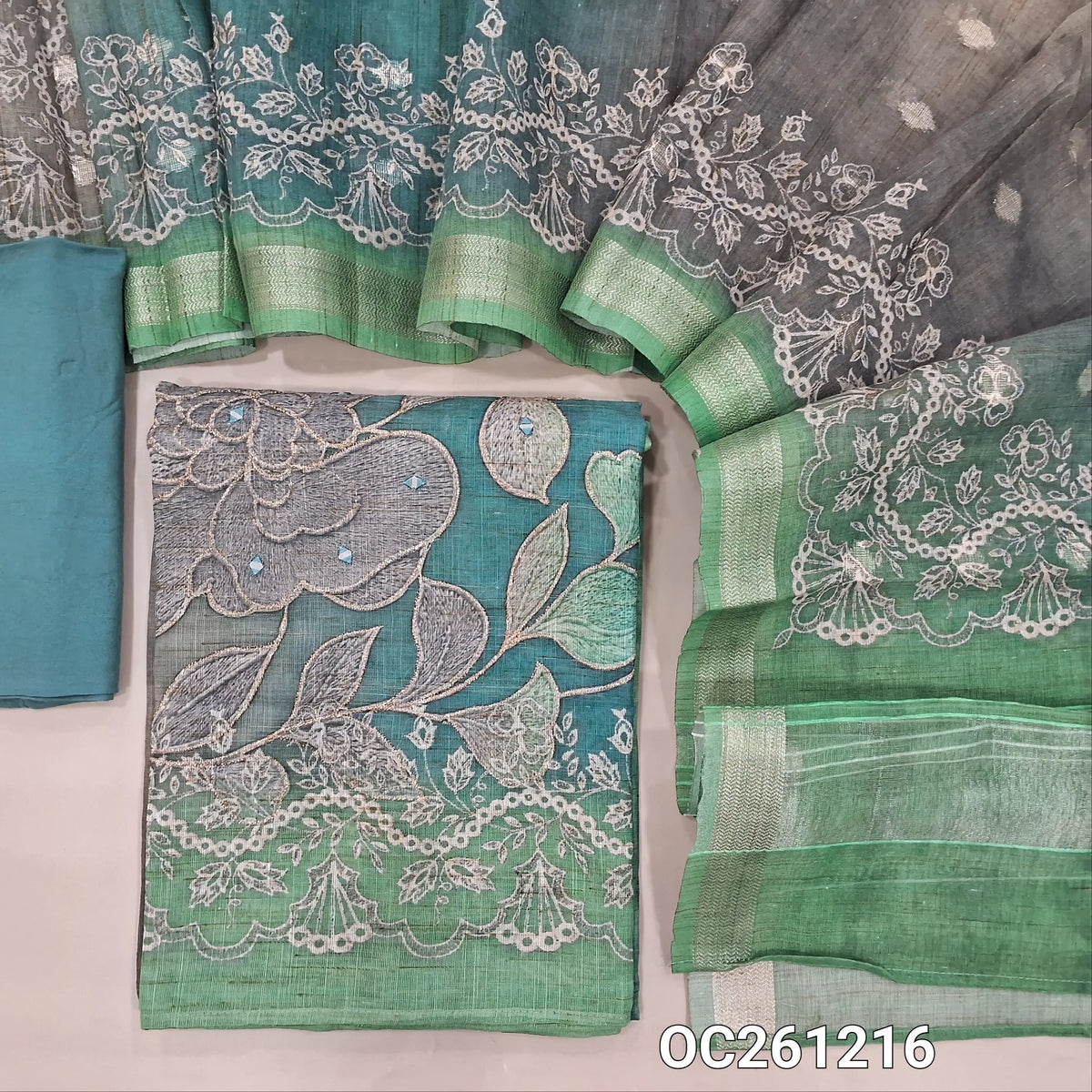 Green & blue dual shaded premium semi linen unstitched salwar material, digital prints with zari and real mirror work on daman,(Textured, Lining Needed)matching santoon bottom, zari buttas and printed premium semi linen dupatta with borders. OC261217