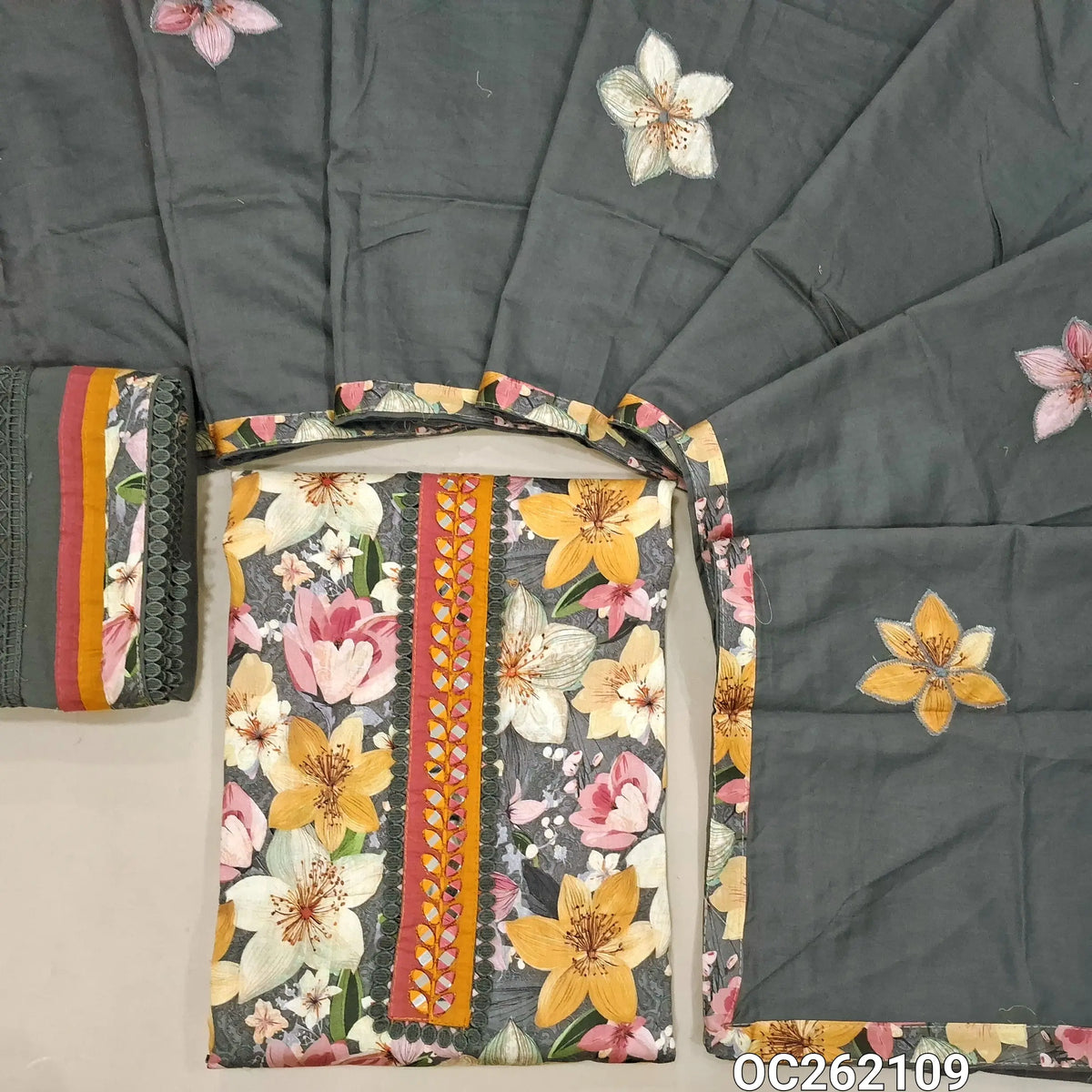 Dark grey floral printed  premium silk cotton unstitched salwar material, real mirror and lace tapping yoke, (Thin, Lining Needed)cotton bottom with cutwork and lace detailing, applique work on silk cotton dupatta with tapping. OC262109