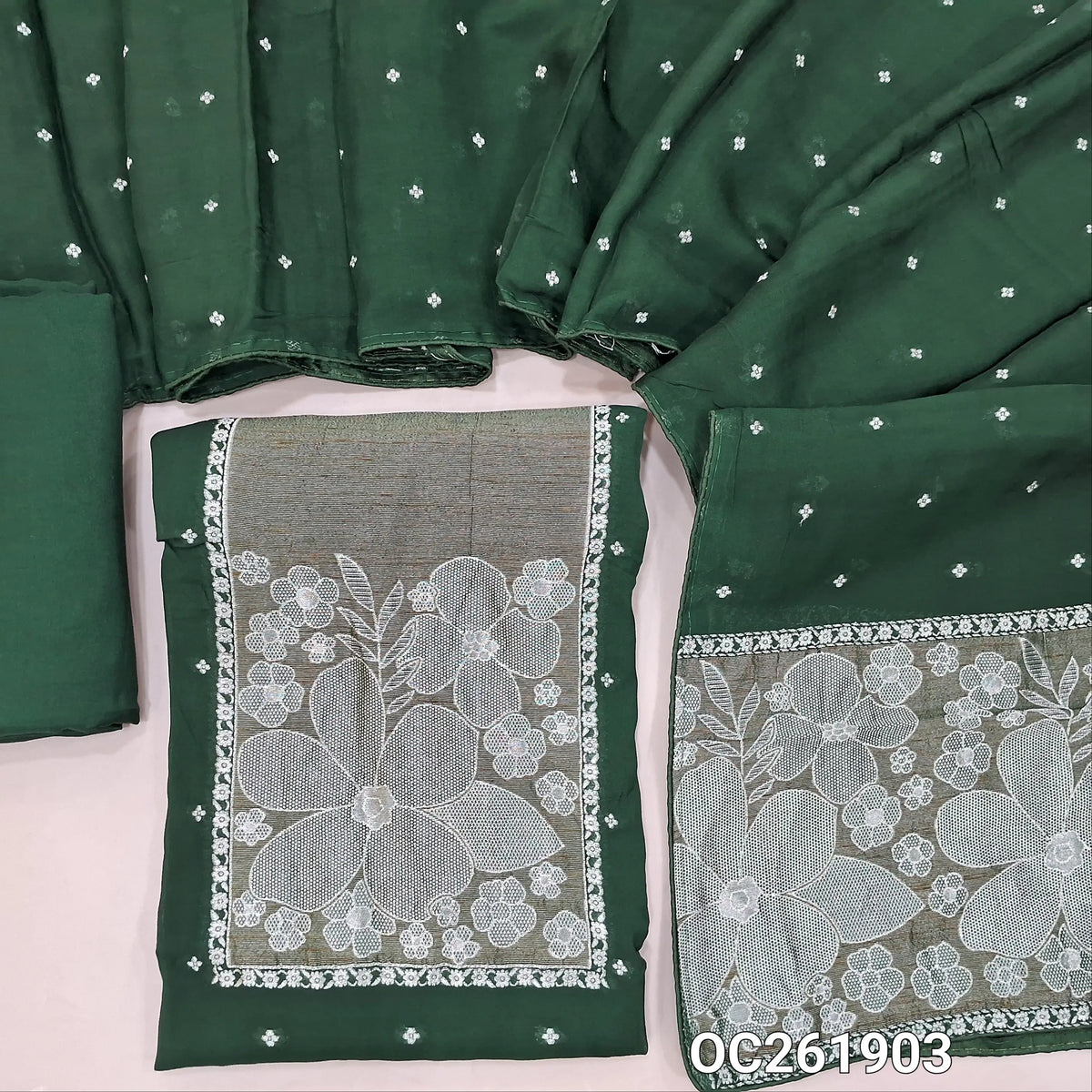 Dark green premium benarasi kora unstitched salwar material, rich silver zari weaving on yoke,silver zari buttas all over,(Soft, Silky, Lining Needed)santoon bottom,silver zari buttas on benarasi kora dupatta with zari weaving. OC261903