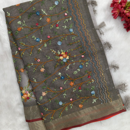 Grey with golden tint premium dual shaded tissue linen saree, with rich hand embroidery detailing all over(textured)double side tissue borders,contrast pallu, with rich hand embroidery and sequins work, running blouse with embroidery & borders. NS267