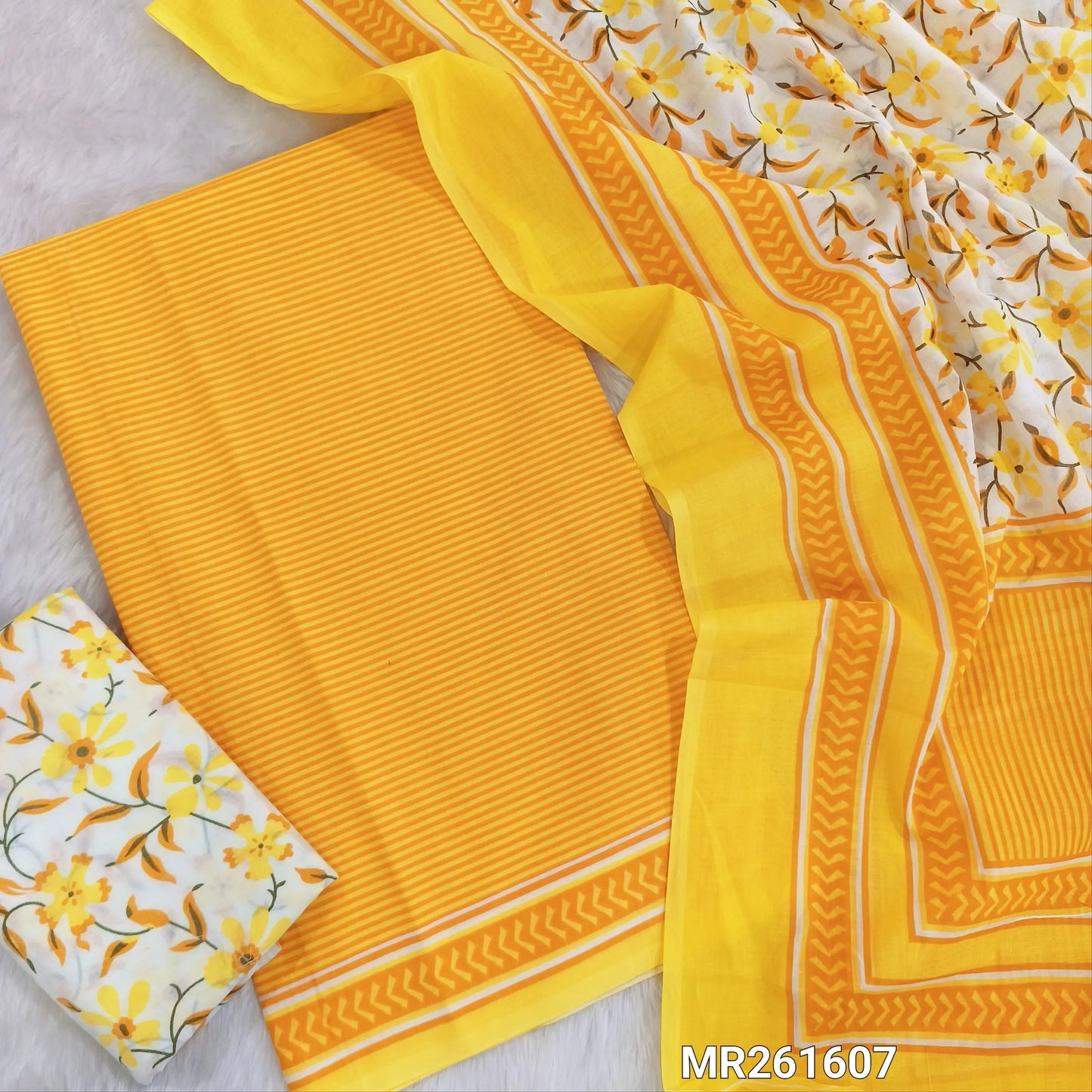Bright yellow cambric cotton unstitched salwar material,vertical stripes all over,(lining optional)floral printed cambric cotton bottom, floral printed full length cambric cotton dupatta with pallu and printed borders. MR261607