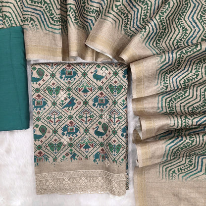 Greyish beige base patola printed semi tussar unstitched salwar material, embroidery on front, embroidered daman (textured, lining needed)teal blue cotton bottom, digital printed semi tussar dupatta. MR260514