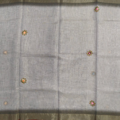Grey with golden tint premium dual shaded tissue linen saree, with rich hand embroidery detailing all over(textured)double side tissue borders,contrast pallu, with rich hand embroidery and sequins work, running blouse with embroidery & borders. NS267