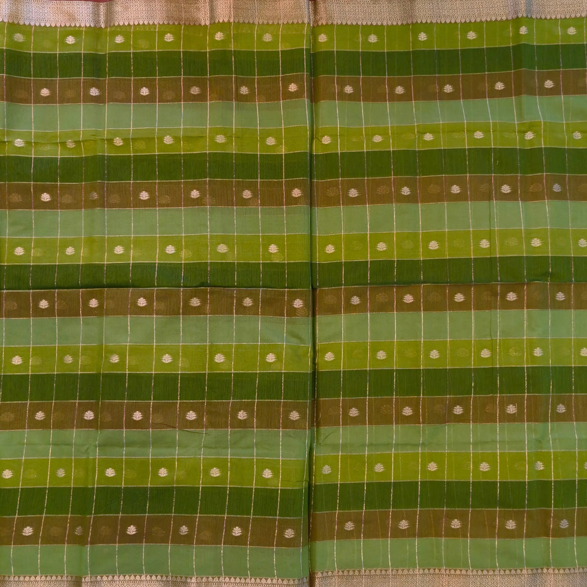 Multicoloured (Light & dark green)soft silk cotton saree with zari woven checks & buttas all over, zari woven double side borders, tissue pallu,multicoloured running blouse with borders & buttas. NS30