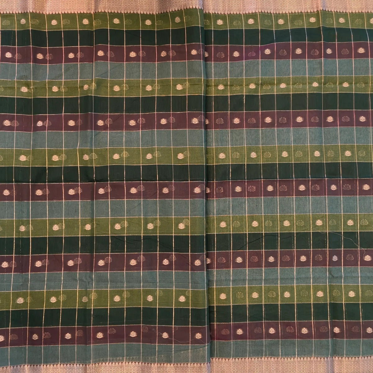 Multicoloured (Dark green & brown)soft silk cotton saree with zari woven checks & buttas all over, zari woven double side borders, tissue pallu,multicoloured running blouse with borders & buttas. NS27