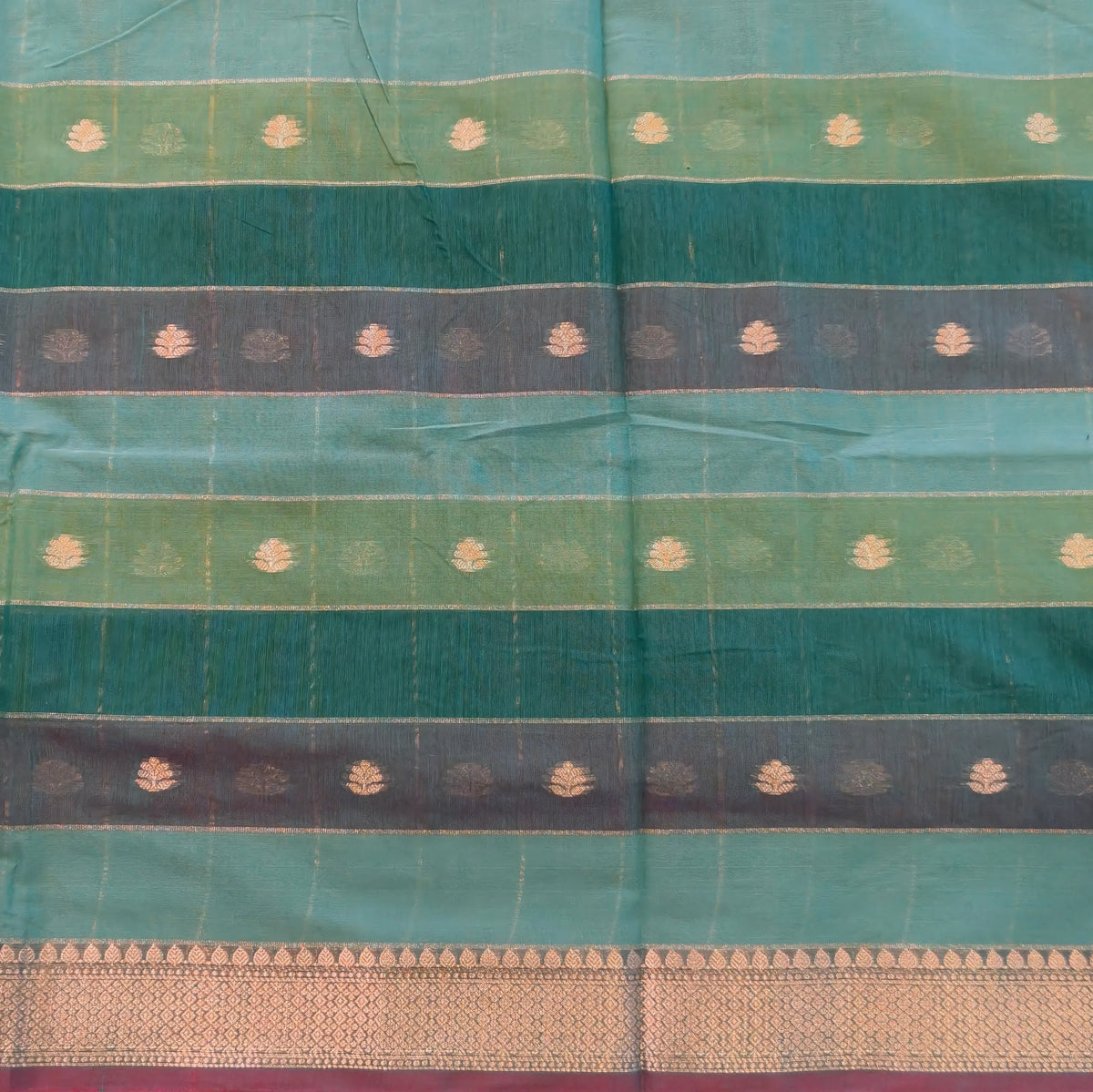 Multicoloured (Turquoise blue & green)soft silk cotton saree with zari woven checks & buttas all over, zari woven double side borders, tissue pallu,multicoloured running blouse with borders & buttas. NS24