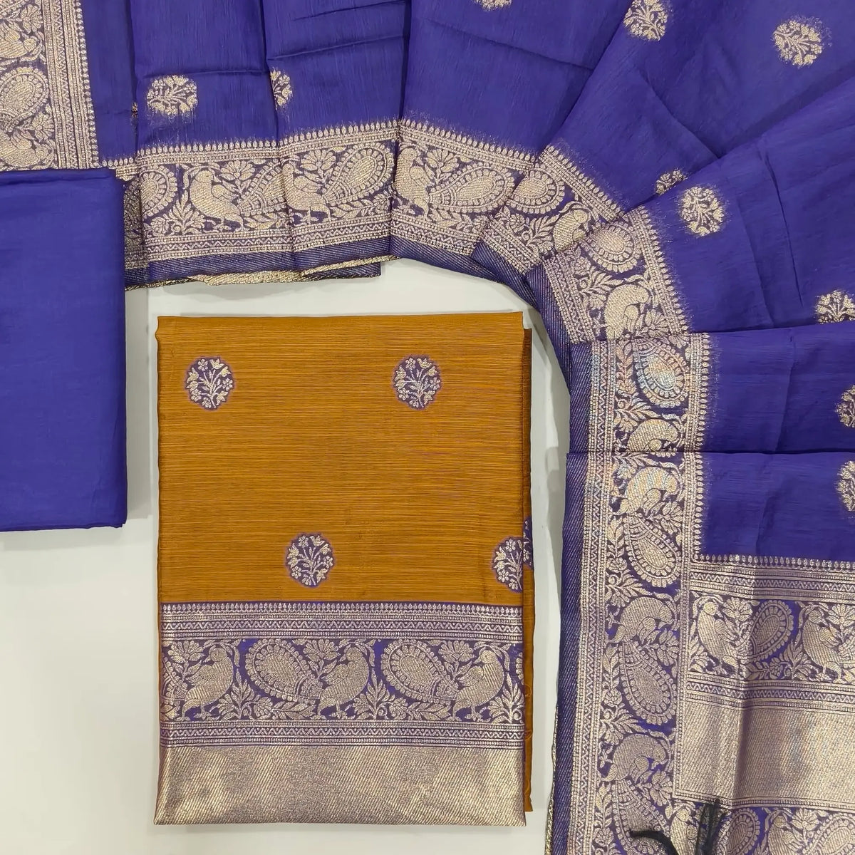 Honey brown benarasi zari woven premium silk cotton unstitched salwar material,buttas on front, zari weaving on yoke, rich daman(Lightweight, Lining Needed)violet silky bottom, benarasi zari woven silk cotton dupatta with borders. OC261713