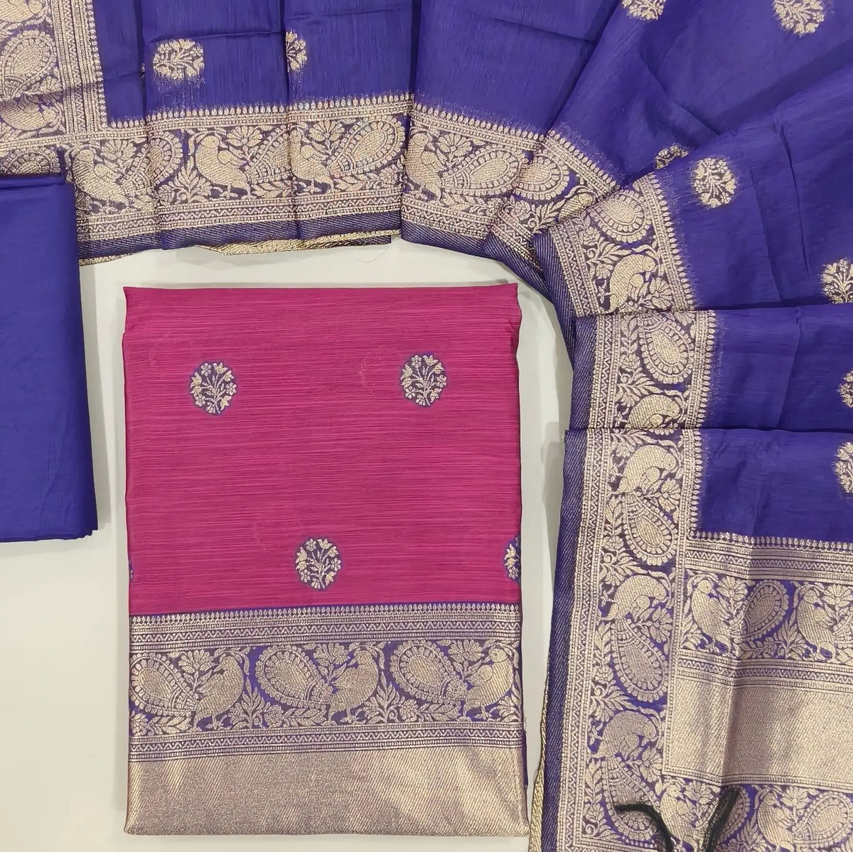 Rani pink benarasi zari woven premium silk cotton unstitched salwar material,buttas on front, zari weaving on yoke, rich daman(Lightweight, Lining Needed)violet silky bottom, benarasi zari woven silk cotton dupatta with borders. OC261712
