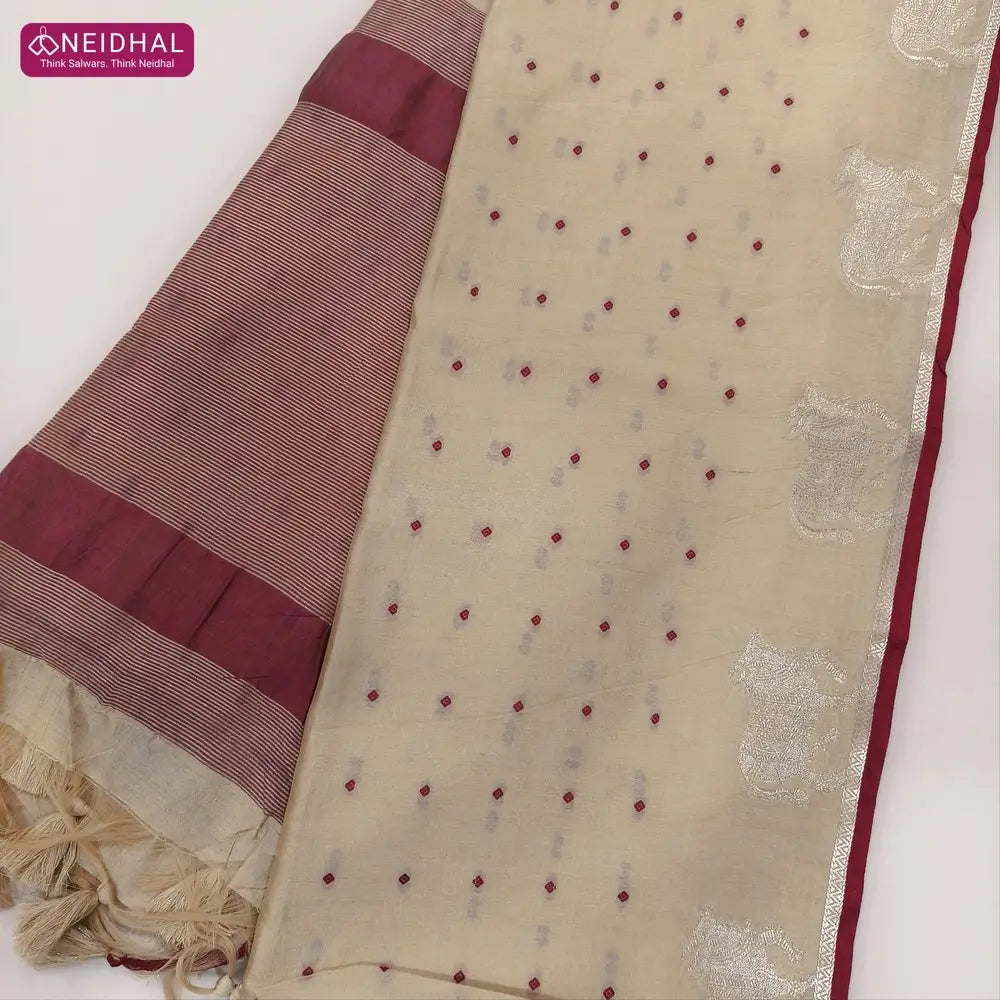 Beige with dark maroon fancy silk cotton saree with thread woven buttas all over the body of the saree, double side borders with pichwai zari short pallu and zari striped blouse with cow motif weaving. CODE NS08