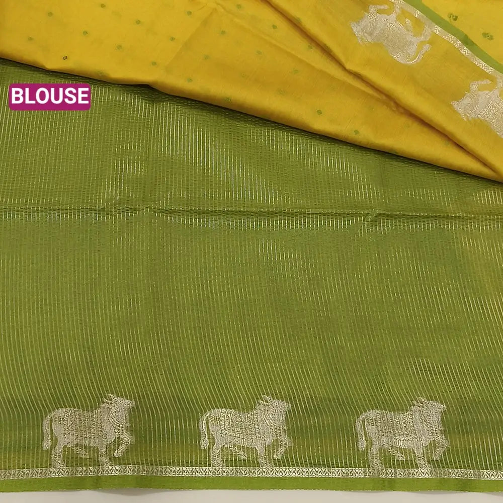 Mehandhi yellow with mossy green fancy silk cotton saree with thread woven buttas all over the body of the saree, double side borders with pichwai zari short pallu and zari striped blouse with cow motif weaving. CODE NS03