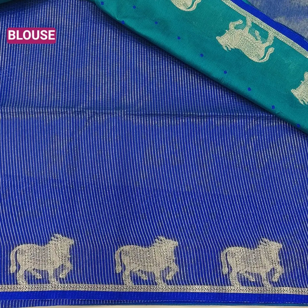 Teal green with royal blue fancy silk cotton saree with thread woven buttas all over the body of the saree, double side borders with pichwai zari short pallu and zari striped blouse with cow motif weaving. CODE NS04