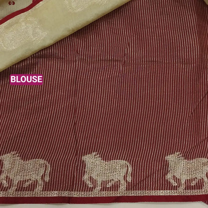 Beige with dark maroon fancy silk cotton saree with thread woven buttas all over the body of the saree, double side borders with pichwai zari short pallu and zari striped blouse with cow motif weaving. CODE NS08