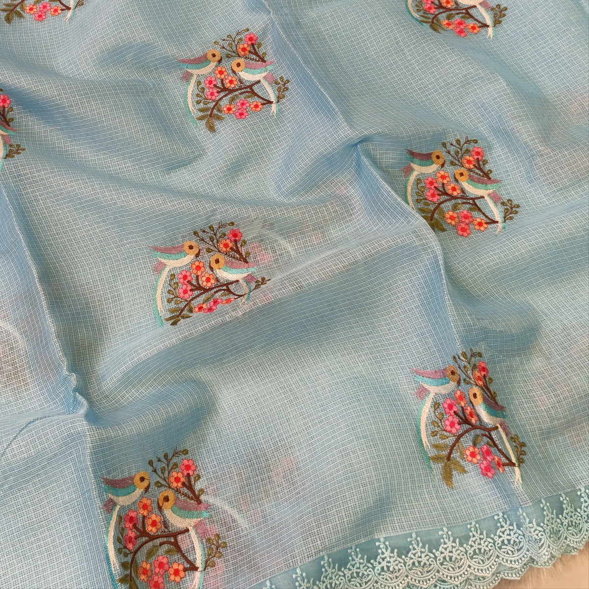 Pastel blue premium kota saree with embroidered bird and floral motifs all over (Thin, Lightweight) lace tapings as borders, rich embroidered pallu, plain running blouse. NS310