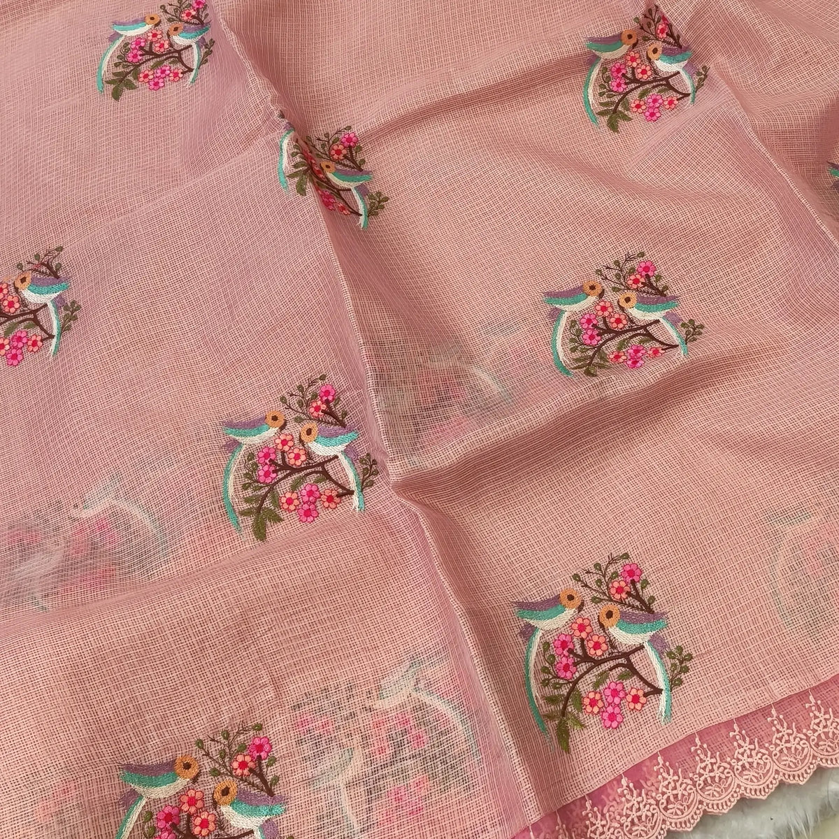 Pastel peach premium kota saree with embroidered bird and floral motifs all over (Thin, Lightweight) lace tapings as borders, rich embroidered pallu, plain running blouse. NS306