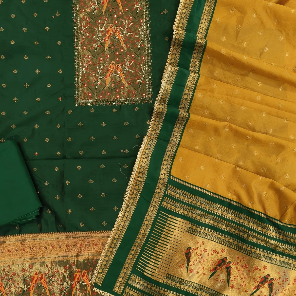 Bottle green silk cotton unstitched salwar material,rich weaving with pearl bead and sequins work on yoke,buttas on front,rich daman,(Lining Needed)spun cotton bottom, buttas on silk cotton dupatta with contrast borders & rich pallu. SP262401