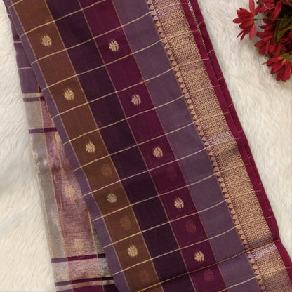 Multicoloured (Purple & maroon)soft silk cotton saree with zari woven checks & buttas all over, zari woven double side borders, tissue pallu,multicoloured running blouse with borders & buttas. NS28