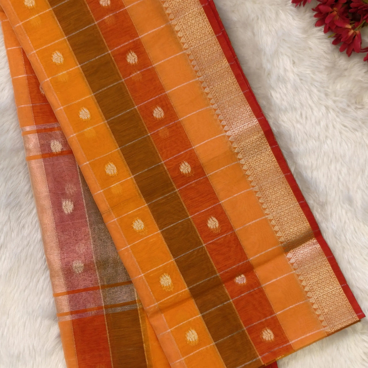 Multicoloured (Orange & yellow)soft silk cotton saree with zari woven checks & buttas all over, zari woven double side borders, tissue pallu,multicoloured running blouse with borders & buttas. NS25