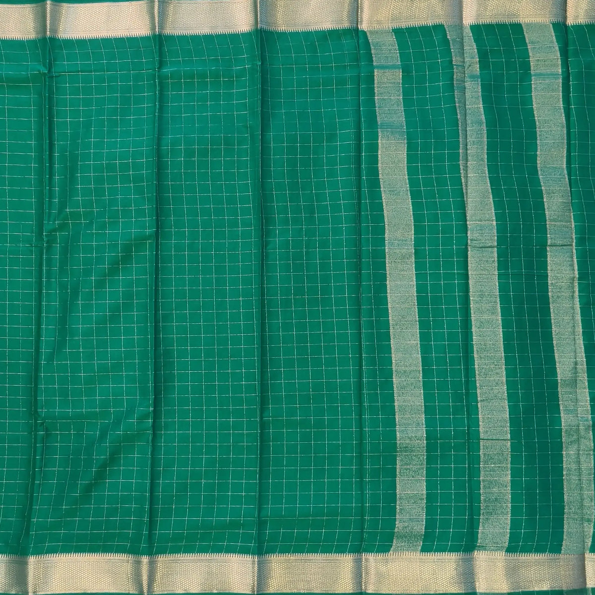 Dark turquiose green soft fancy crepe silk saree,zari checks all over,(soft,thin)striped tissue pallu,double side zari woven borders,running blouse with zari checks and borders. NS239
