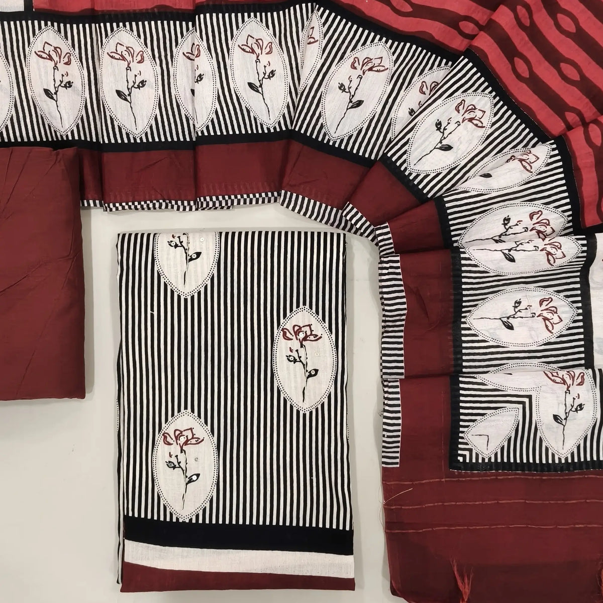 Black & white pure cotton unstitched salwar material,vertical printed and floral printed with sequins all over (lining optional)maroon cotton bottom,block printed chanderi silk cotton dupatta(Tapping  needed). OC261304
