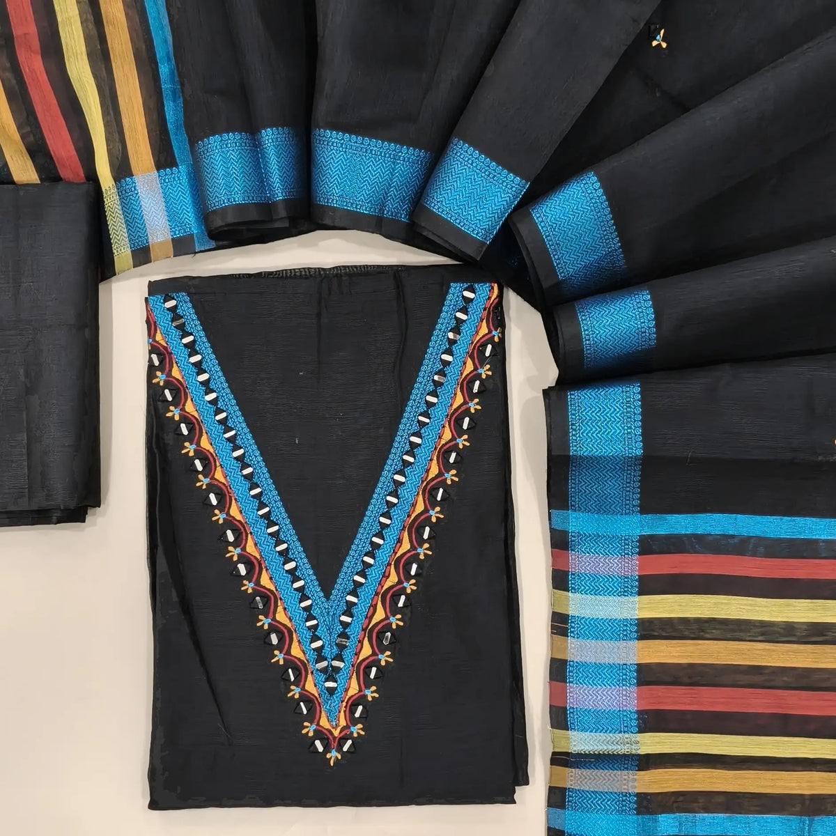 Designer black silk cotton unstitched salwar material, thread borders and real mirror(lining needed)silk cotton bottom,embroidery and real mirror silk cotton dupatta with blue zari borders & pallu. OC261316