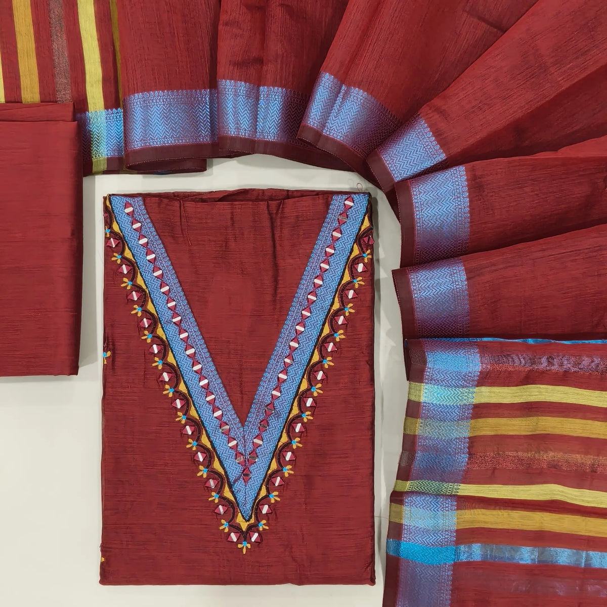 Designer maroon silk cotton unstitched salwar material, thread borders and real mirror(lining needed)silk cotton bottom,embroidery and real mirror silk cotton dupatta with blue zari borders & pallu. OC261317